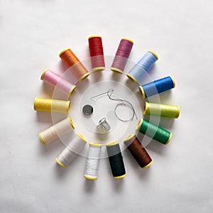 Spools of thread in circle with needle thimble and button