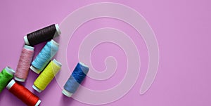 spools of thread on a pink background, photos for a sewing workshop, a banner for an atelier, sewing threads, a place