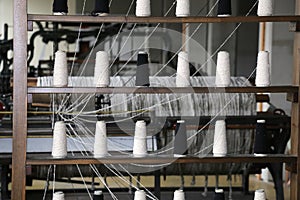 spools of thread to spin in the old industrial weaving loom fabr
