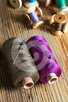 Spools of thread on wooden background. Old sewing accessories.