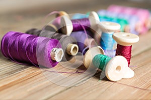 Spools of thread on wooden background. Old sewing accessories.