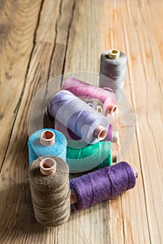 Spools of thread on wooden background. Old sewing accessories.