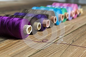 Spools of thread on wooden background. Old sewing accessories. c