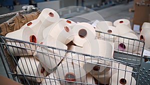 Spools of yarn thread in a basket. Yarn making processes. Textile factory equipment. Spinning production. Threads