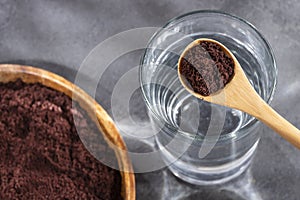 Spoon with acai powder to mix with water - Euterpe oleracea photo