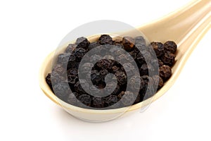 Spoon of black peppercorns