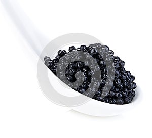 Spoon with black sturgeon caviar isolated on white background