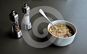 spoon in bowl with soup on gray table in restaurant