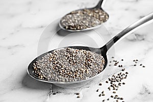 Spoon with chia seeds on marble background,