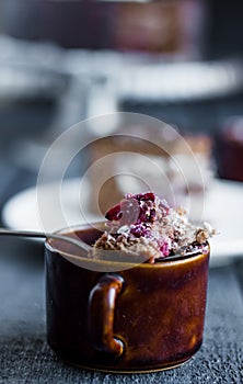 Spoon with chocolate cake with butter cream and cherries, cup
