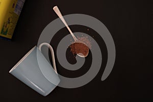 Spoon of cocoa powder and a cup.
