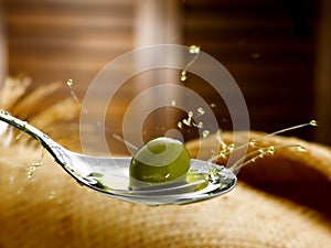 Spoon with extra virgin olive oil and olive