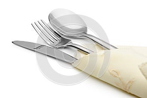 Spoon, fork and a knife lie on serviette