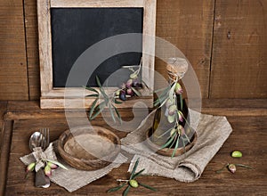 Spoon, fork and olives and olive oil, menu black blackboard on