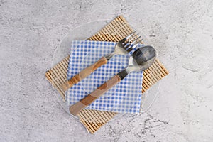 Spoon and fork placed on blue and white handkerchiefs