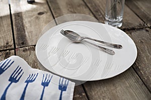 Spoon and Fork on White Dinner Plate with Engraved Fork Pattern