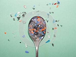 Spoon is full of small and colorful pieces of plastic