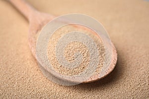 Spoon with granulated yeast, closeup view. Ingredient for baking