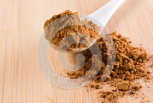 Spoon with guarana on a wooded plate