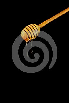 Spoon of honey. On a black background. Dripping fresh honey.