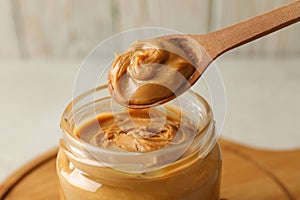 Spoon and jar with peanut butter, close up