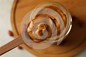 Spoon and jar with peanut butter, close up