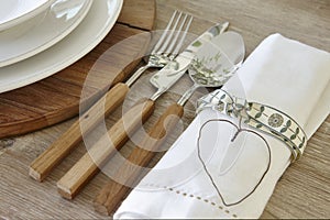 Spoon knife fork and dishware over a rustic table