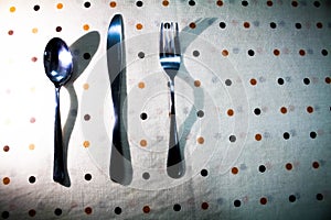 Spoon Knife and a Fork organized ina dottef background textile table