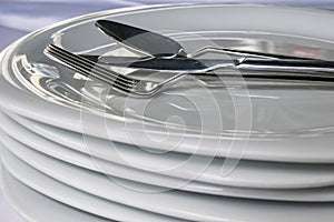 Spoon, knive, fork on plates in restaurant