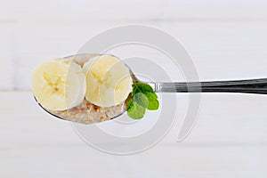 Spoon of oatmeal porridge with banana