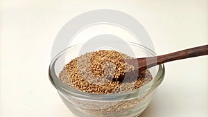 Spoon out of Anise seeds from the glass bowl with a wooden spoon, herbs and spices.