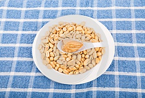 Spoon of Peanut Butter on Bowl of Peanuts