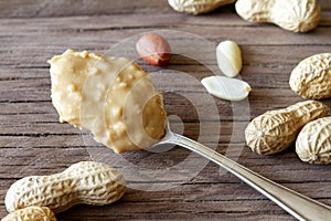 Spoon of peanut butter and peanuts on wooden boards, healthy nutritious snack