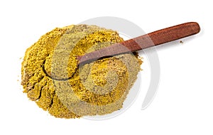 Spoon on pile of spice mix khmeli suneli on white