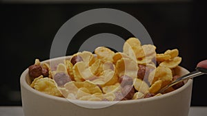 A spoon poured into corn flake plate on black