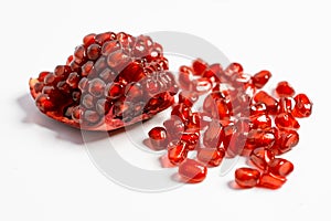 Spoon with ripe pomegranate seeds on a white isolated background