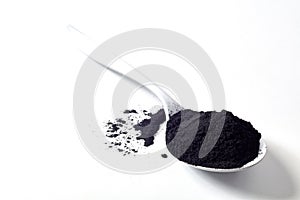 Spoon of round activated black plant charcoal