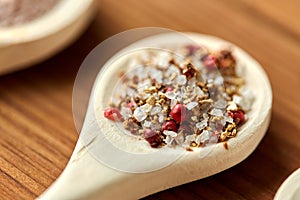 Spoon with salt and spices on wooden table