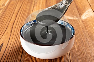 A spoon taking out black sesame paste