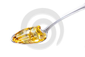 Spoonful of fish oil gel capsule containing omega-3 polyunsaturated acid EPA and DHA enhances heart and health