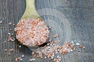 Spoonful of Pink Himalayan Salt on Rustic Wood Background with t