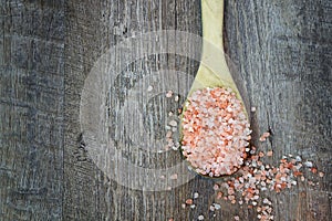 Spoonful of Pink Himalayan Salt on Rustic Wood Background with t