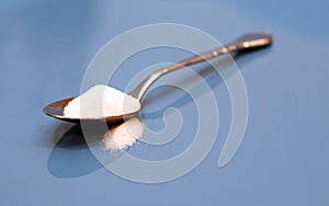Spoonful of sugar on blue background