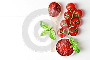 A spoonful of tomato sauce, fresh green basil, tomato sauce