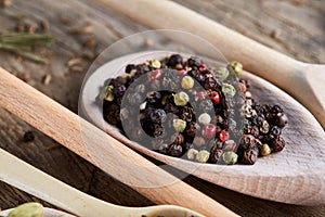 Spoons with aromatic various spices for cooking on old wooden board, close-up, flat lay, selective focus.