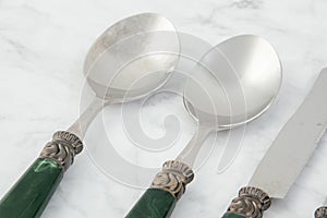 Spoons and knif on white gray background