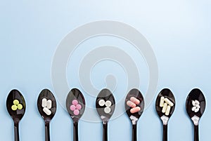 Spoons with pills on a blue background. Medicine. Medication. Health