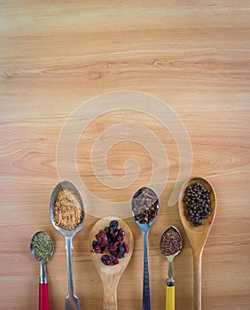 Spoons with spices and dried fruit and copy space