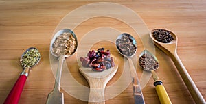 Spoons with spices and dried fruit and copy space