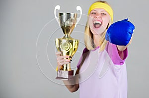 Sport achievement. Celebrate victory. Boxing champion. Athletic girl boxing glove and golden goblet. Woman wear sport